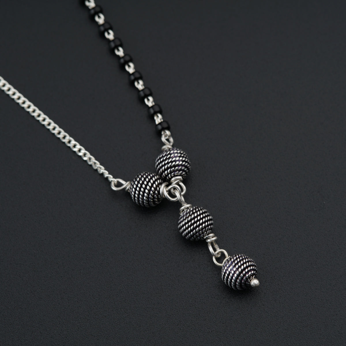 a black and white necklace with two balls on it