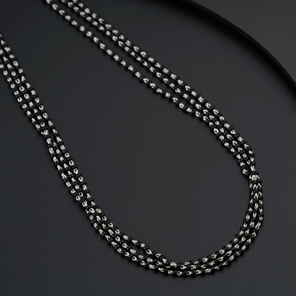 a black and silver chain on a black surface