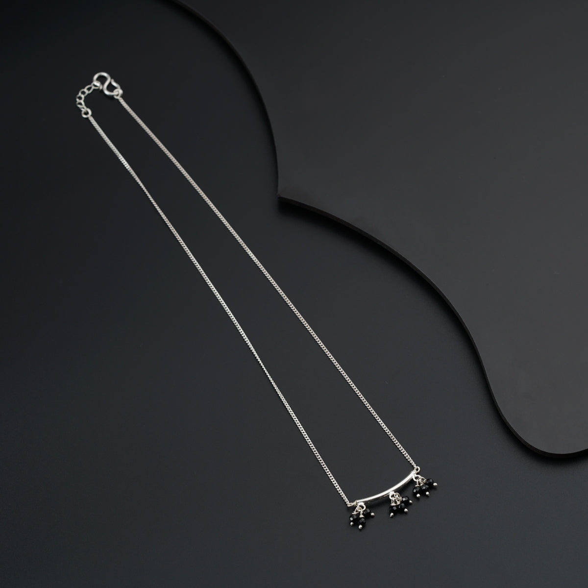 a pair of necklaces on a black surface