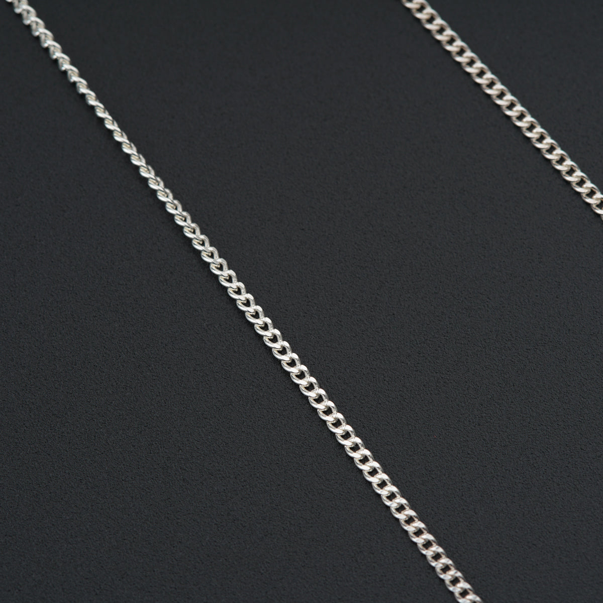 a close up of a chain on a black surface