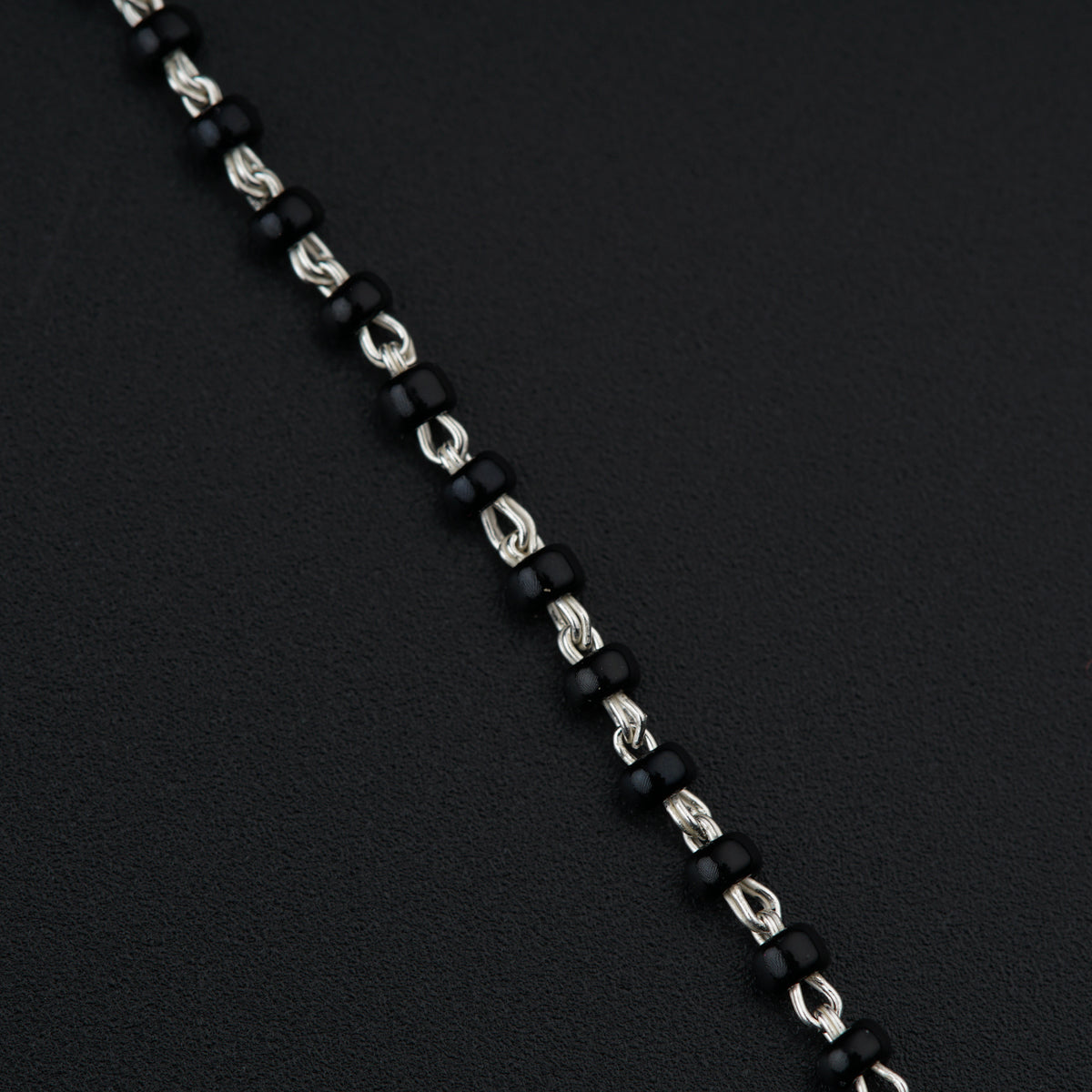 a black and silver chain with a red heart on it