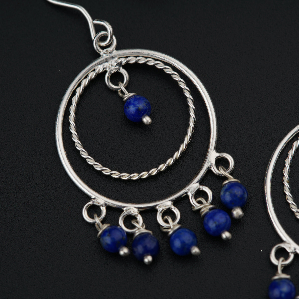 a pair of silver hoop earrings with blue beads