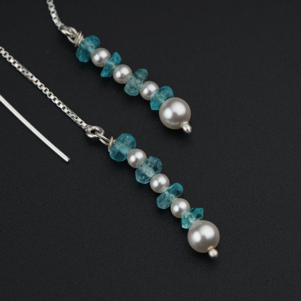 a close up of a necklace with pearls and beads