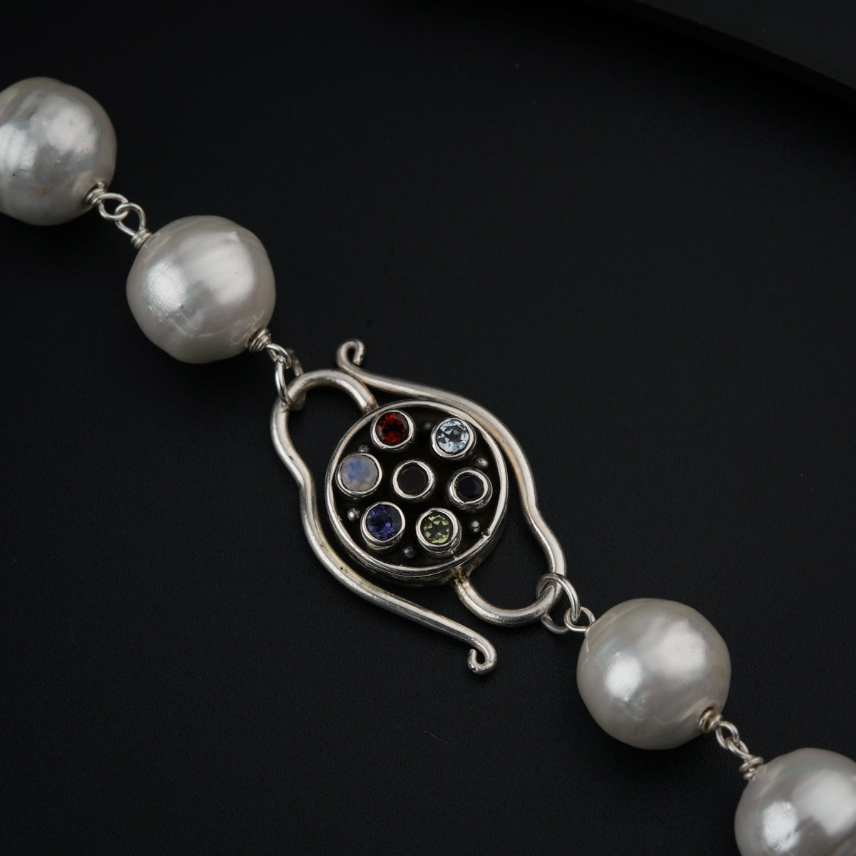 a silver bracelet with a bunch of pearls on it