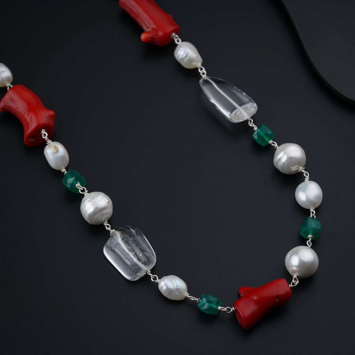 a necklace with a red, white, and green bead