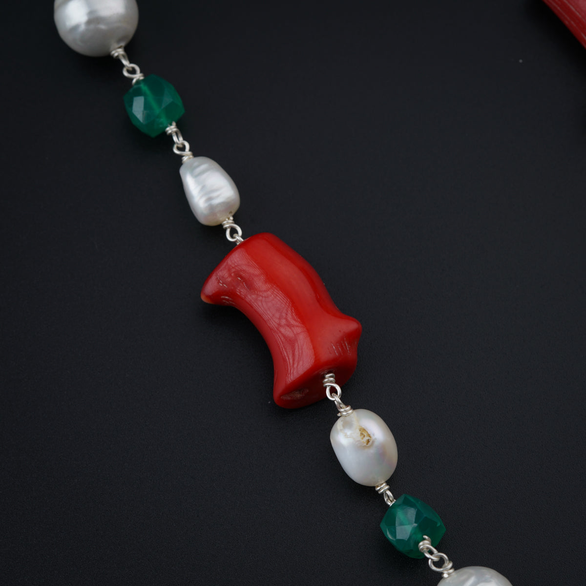 a red, white, and green necklace with pearls