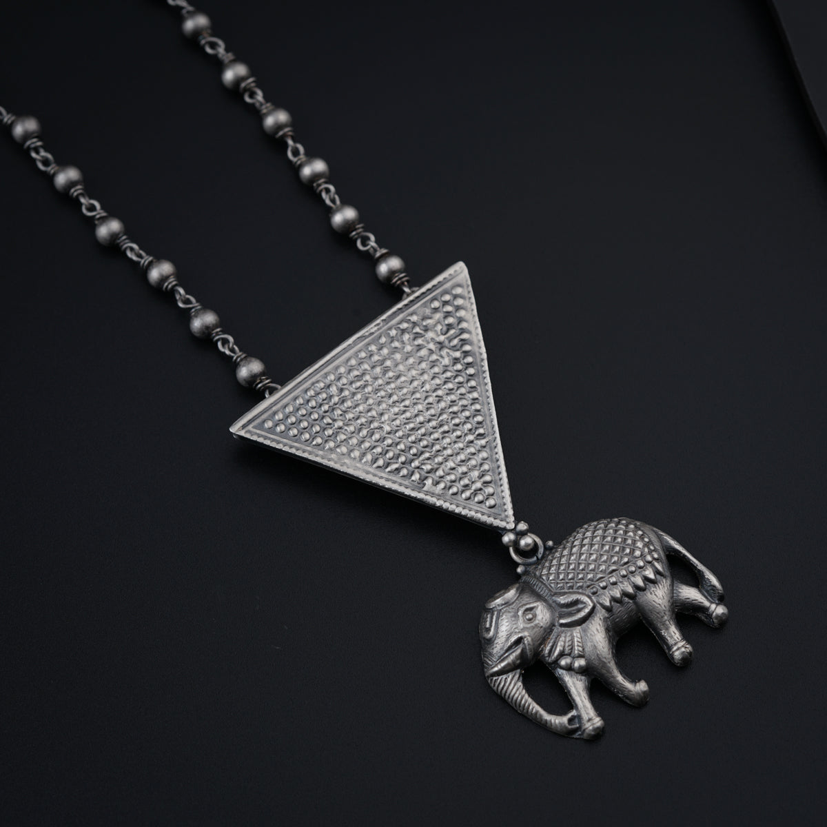 a silver necklace with an elephant on it