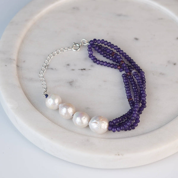 Flat-lay of a purple jade & Baroque Pearl Silver Bracelet with natural purple jade, baroque pearls, and complementary silver jewelry