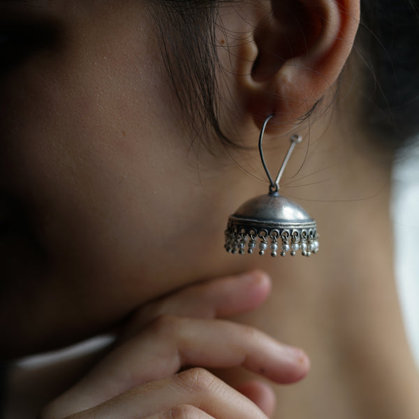a close up of a person wearing a pair of earrings