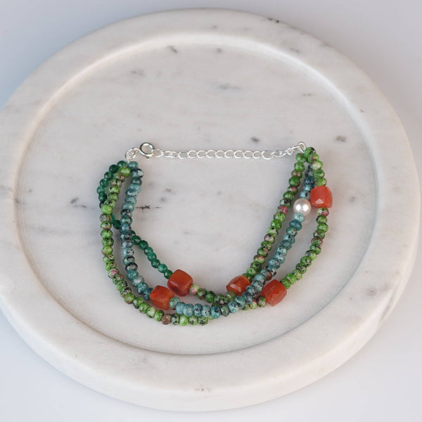 Flat-lay of Carnelian, Green Onyx, Green Jade & Blue Jade Silver Bracelet with colourful natural gemstones and complementary silver jewelry