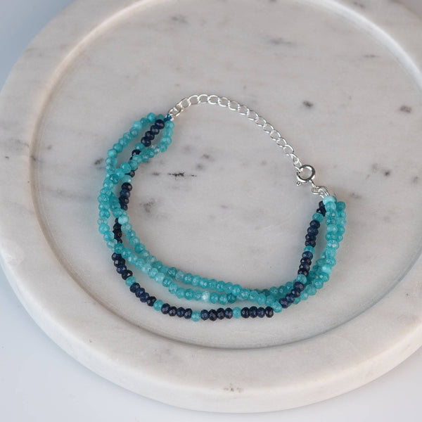 Flat-lay of Dark & Light Blue Jade Silver Bracelet with natural blue jade stones and complementary silver jewelry