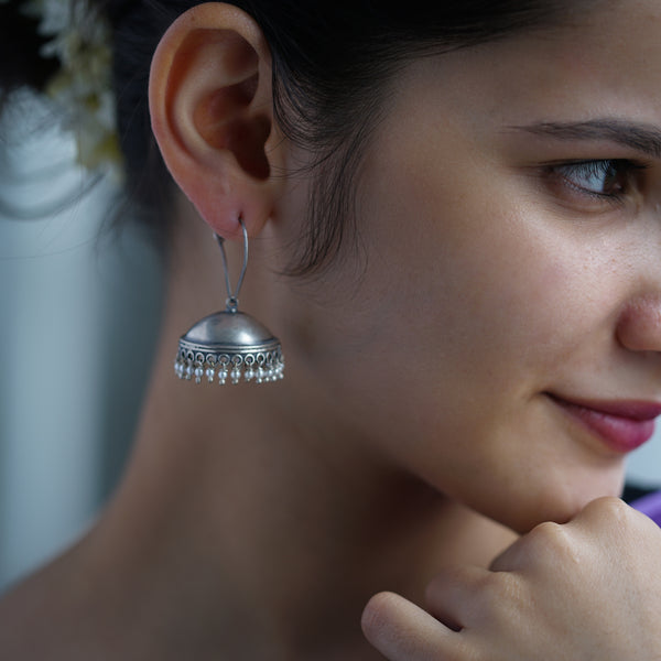 a close up of a person wearing a pair of earrings