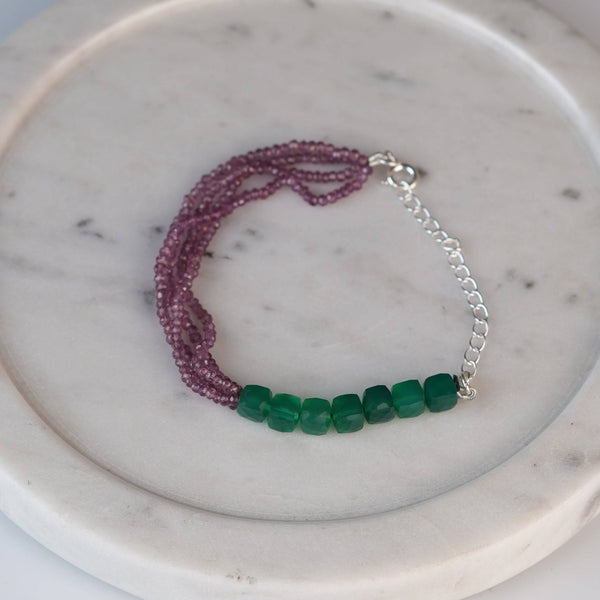 Flat-lay of a green onyx & Rhodonite Silver Bracelet with natural green onyx, rhodonite stones, and complementary silver jewelry