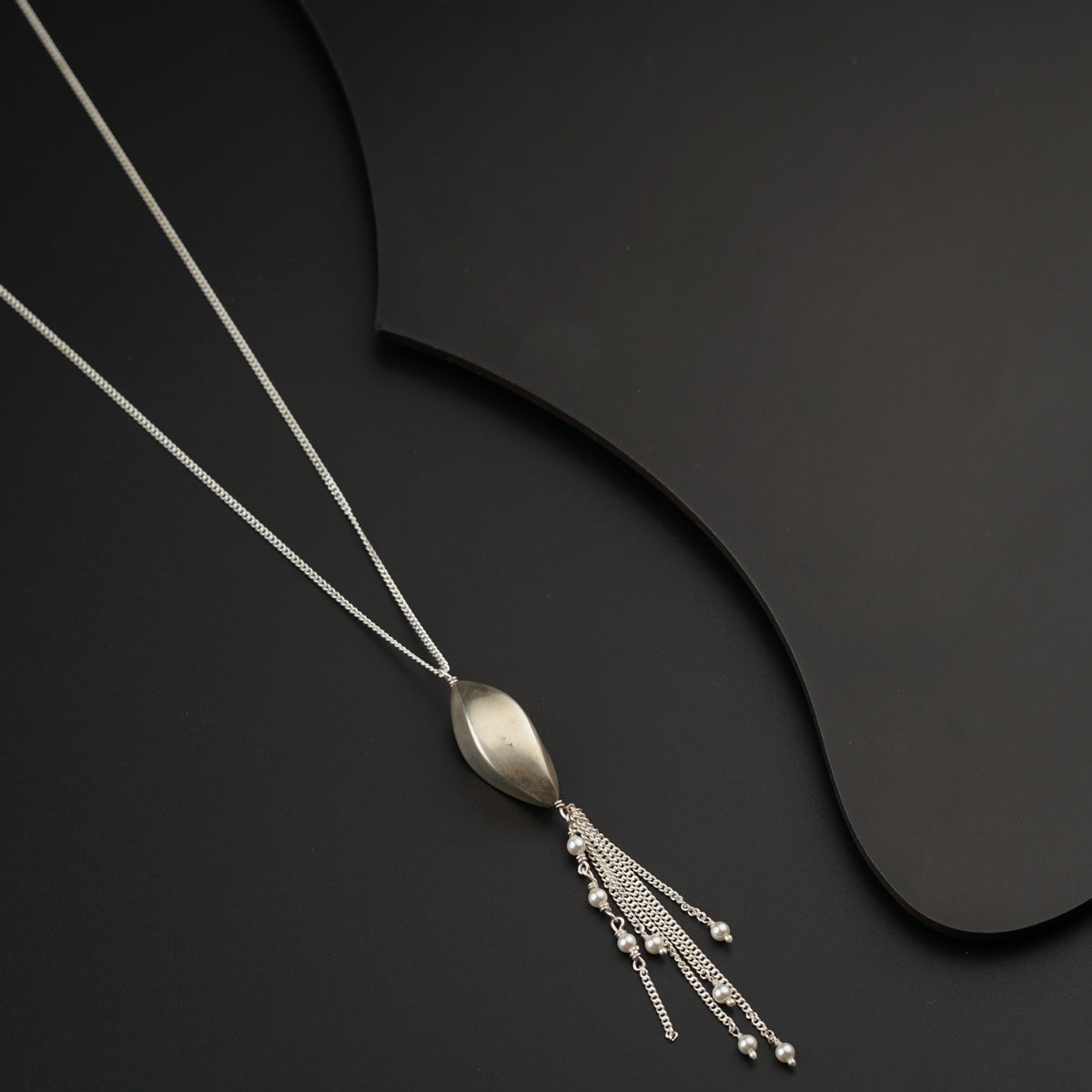 a silver necklace with a long tassel hanging from it