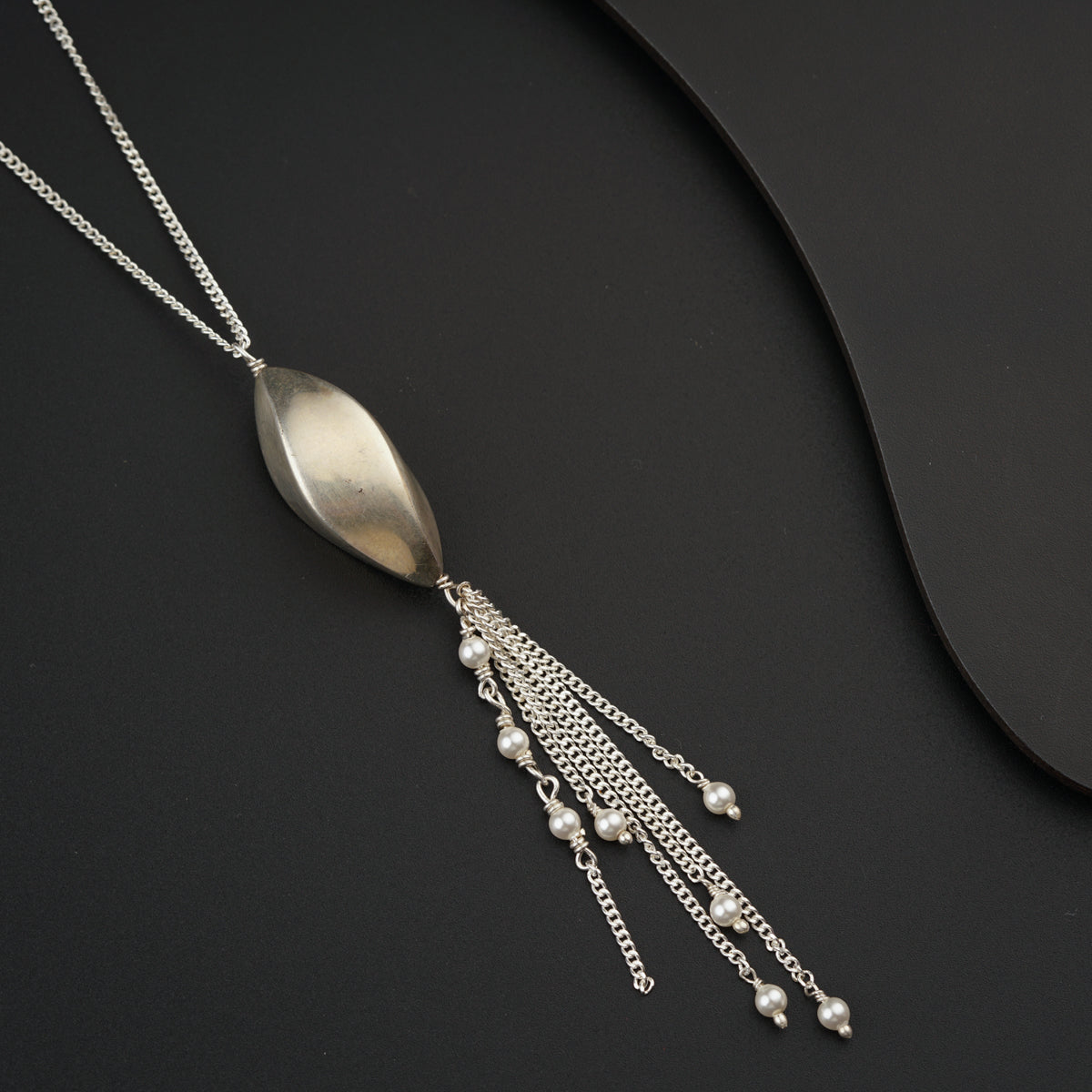 a silver spoon with a chain hanging from it