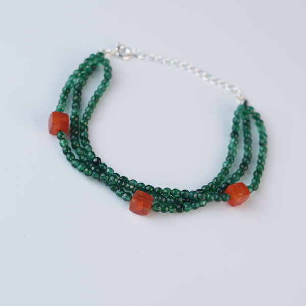 Flat-lay of a green onyx & Carnelian Silver Bracelet with natural gemstones and complementary handcrafted silver jewelry