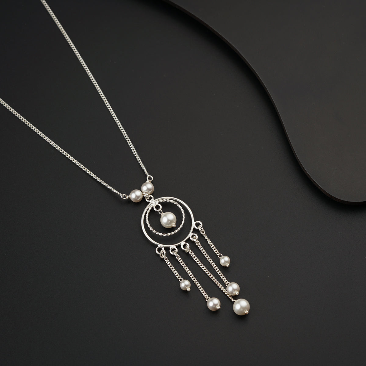 a silver necklace with pearls hanging from it
