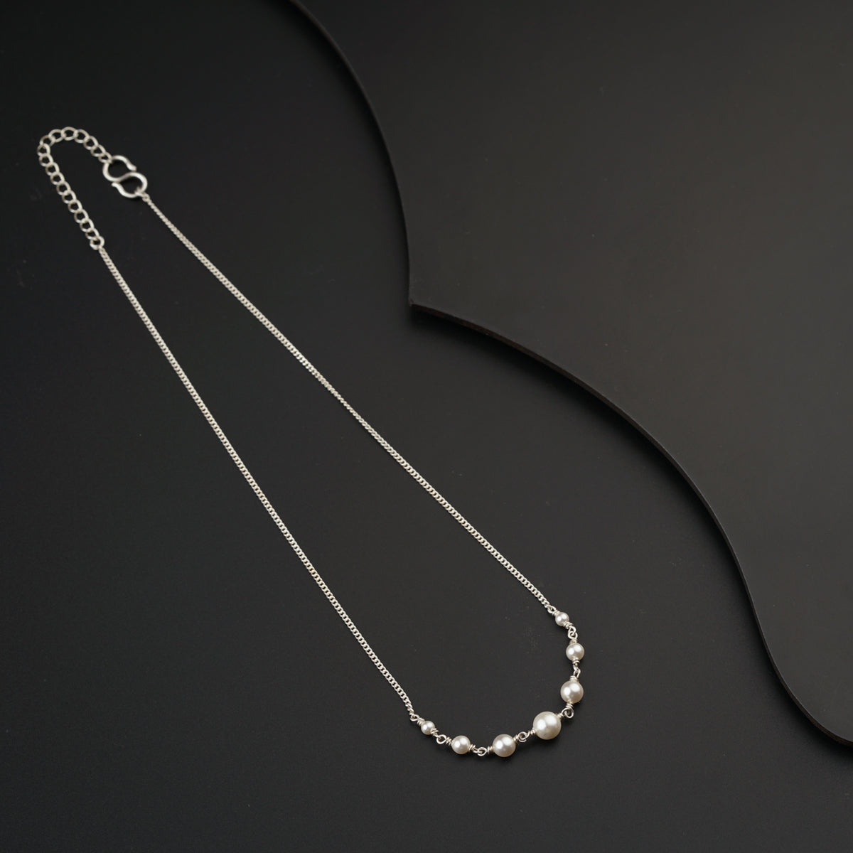 a necklace with pearls on a black background