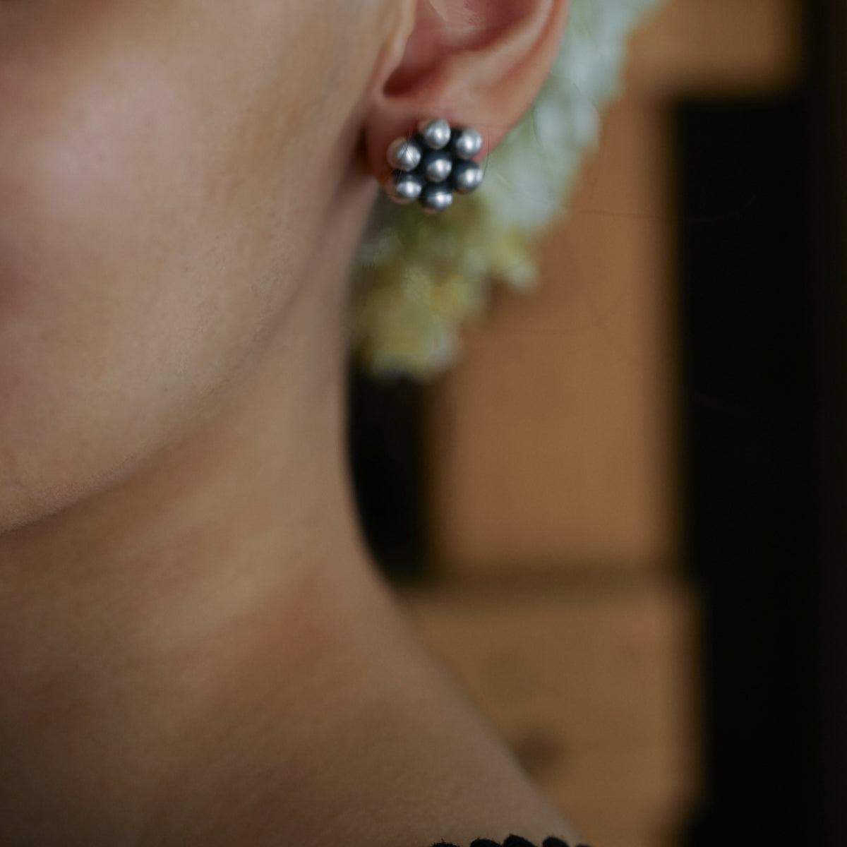 a close up of a person wearing a pair of earrings