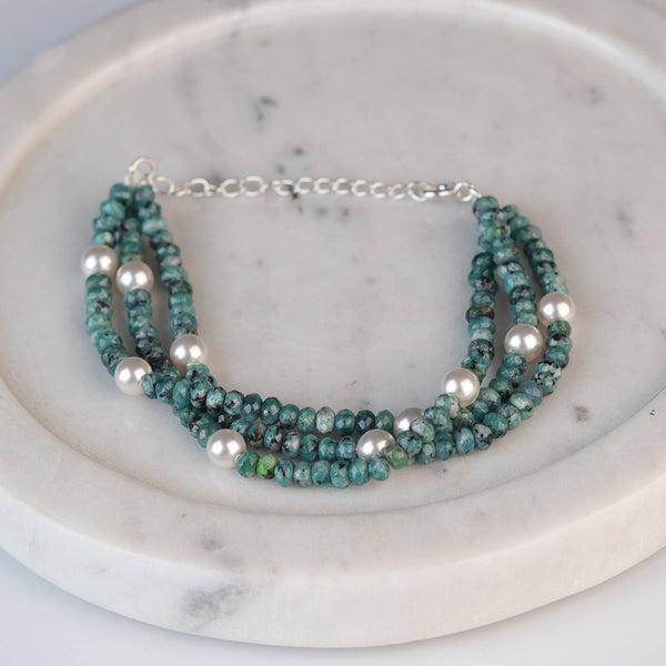 Flat-lay of Blue Jade & Pearl Silver Bracelet with natural blue jade, pearls, and complementary silver jewelry