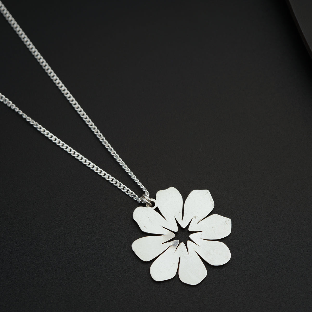 a necklace with a flower cut out of it