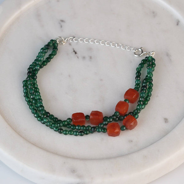 Flat-lay of a green onyx & Carnelian Silver Bracelet with natural gemstones and complementary handcrafted silver jewellery