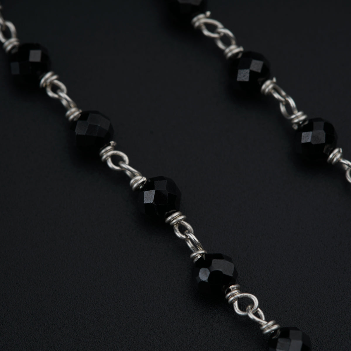 a close up of a chain with black beads