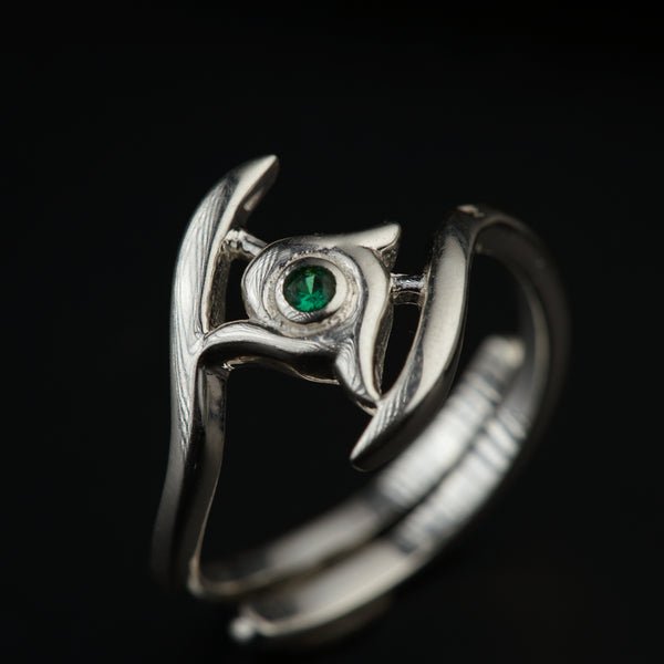 a close up of a ring with a green stone
