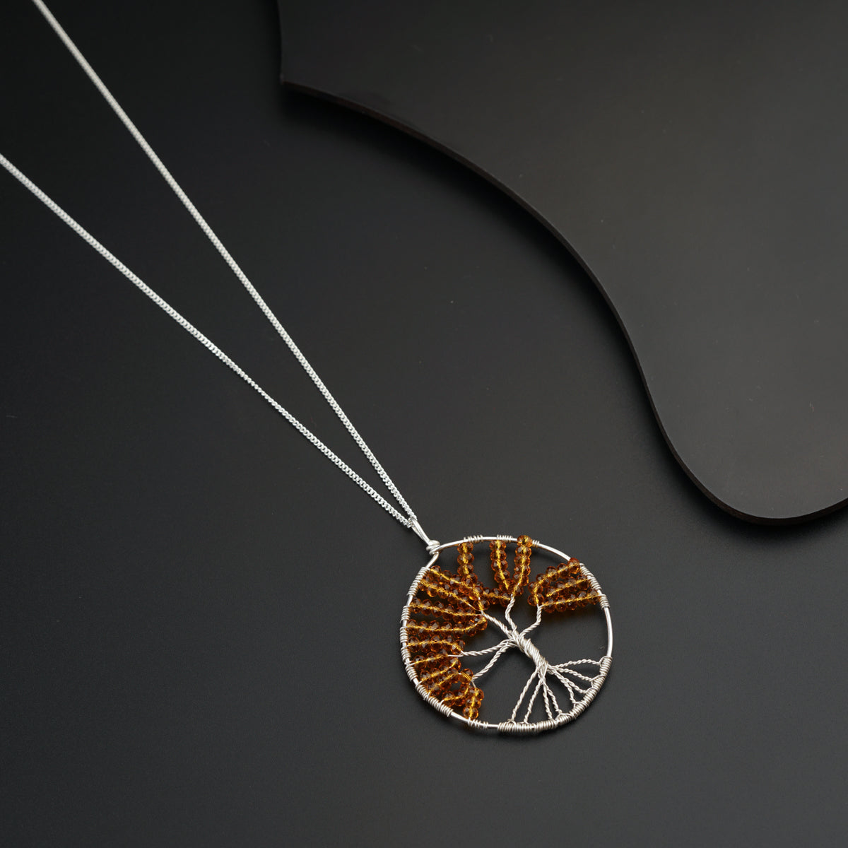 a necklace with a tree of life design on it