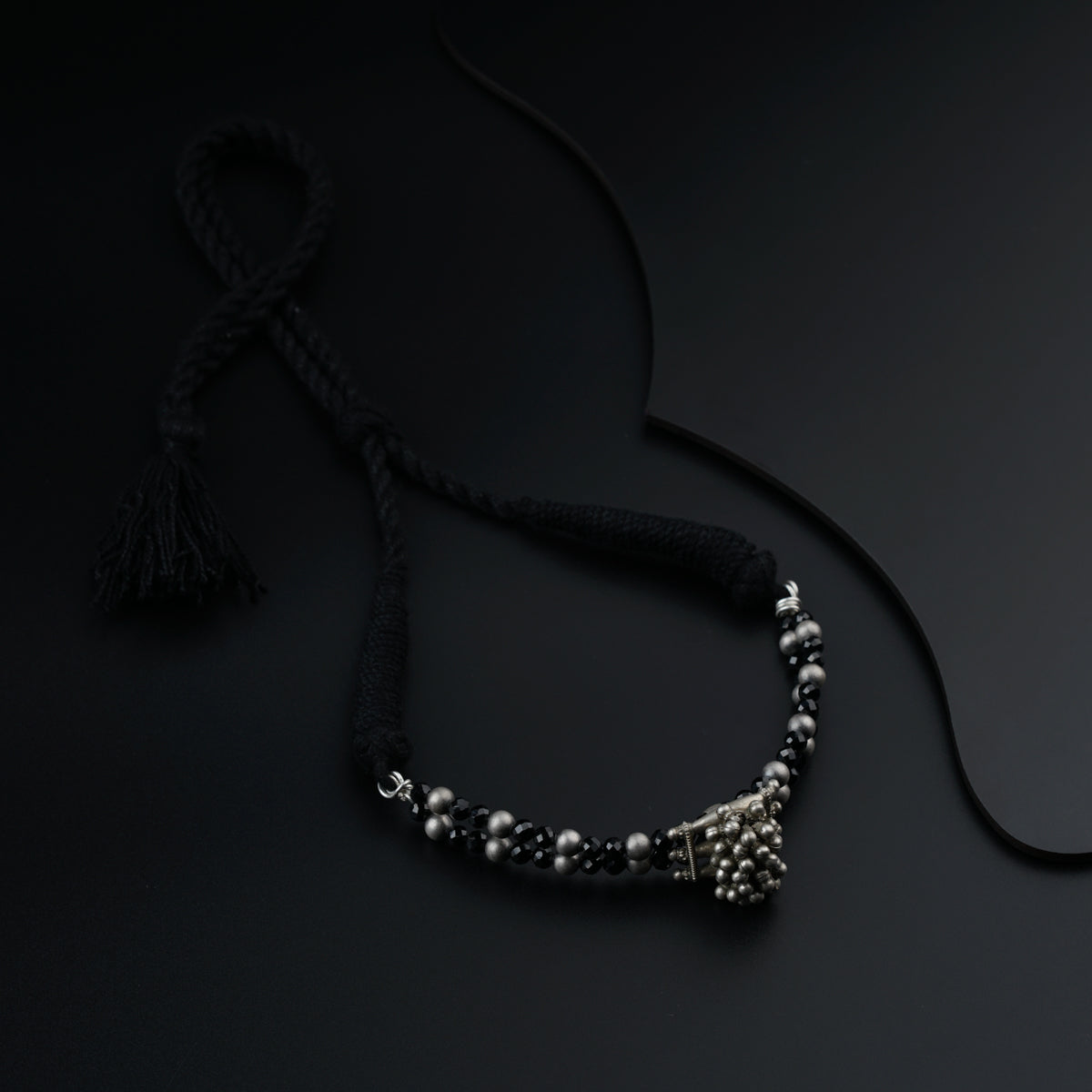 a black beaded necklace on a black background