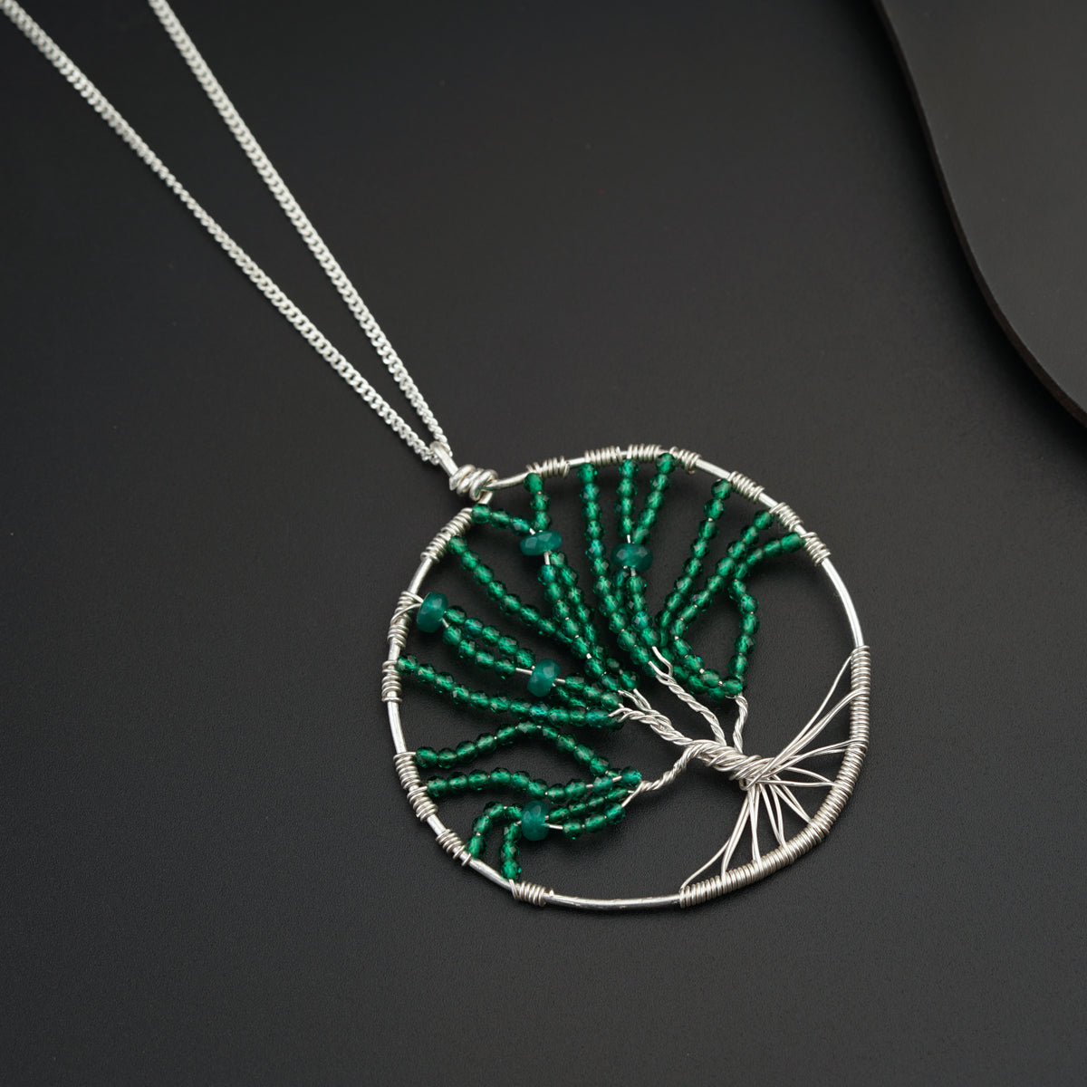 a necklace with a tree of life design on it