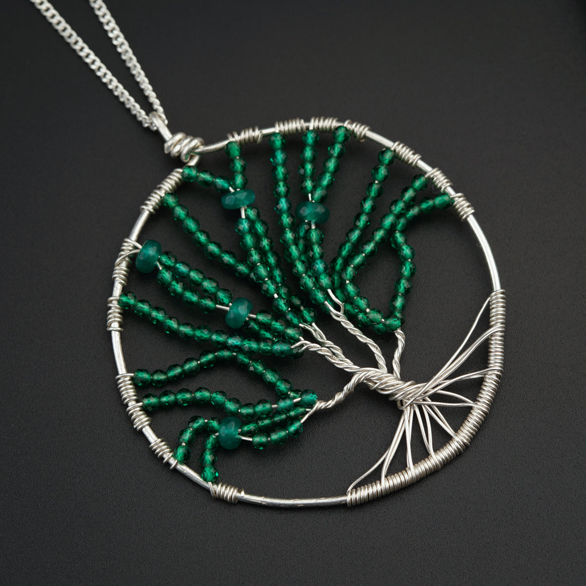 a tree of life pendant with green beads