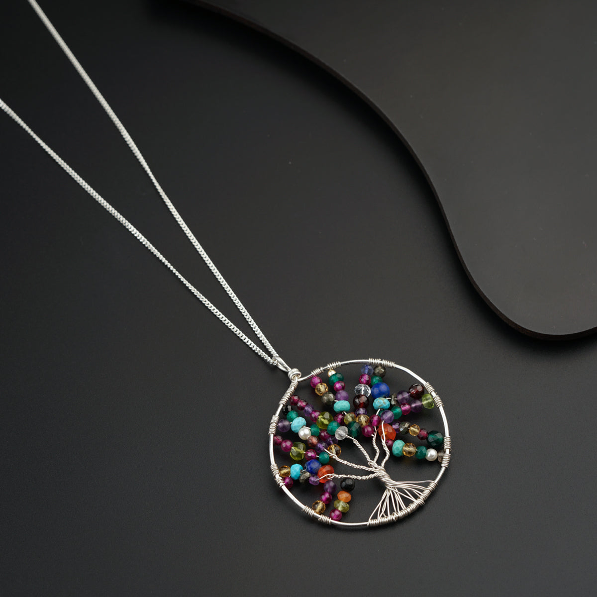 a tree of life pendant with multicolored beads