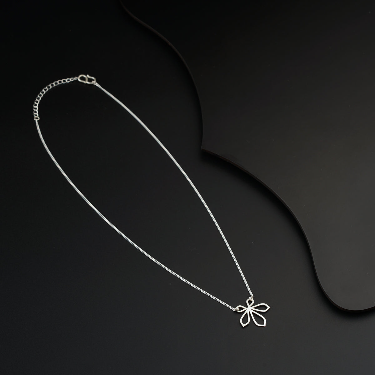 a necklace with a bow on a black background
