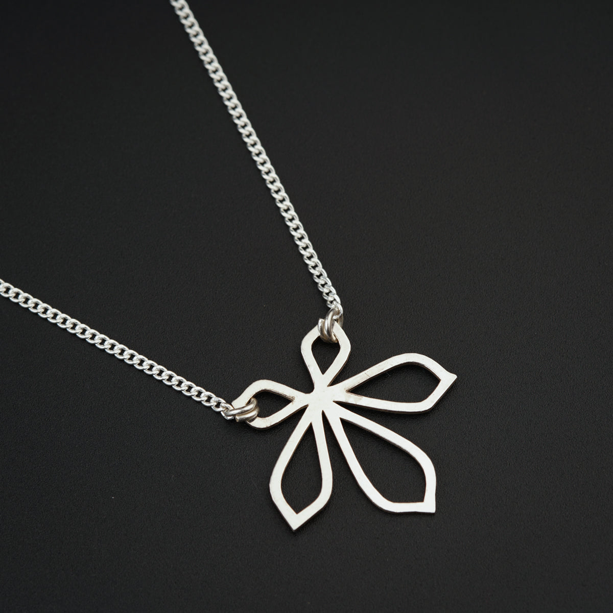 a silver necklace with a flower on it