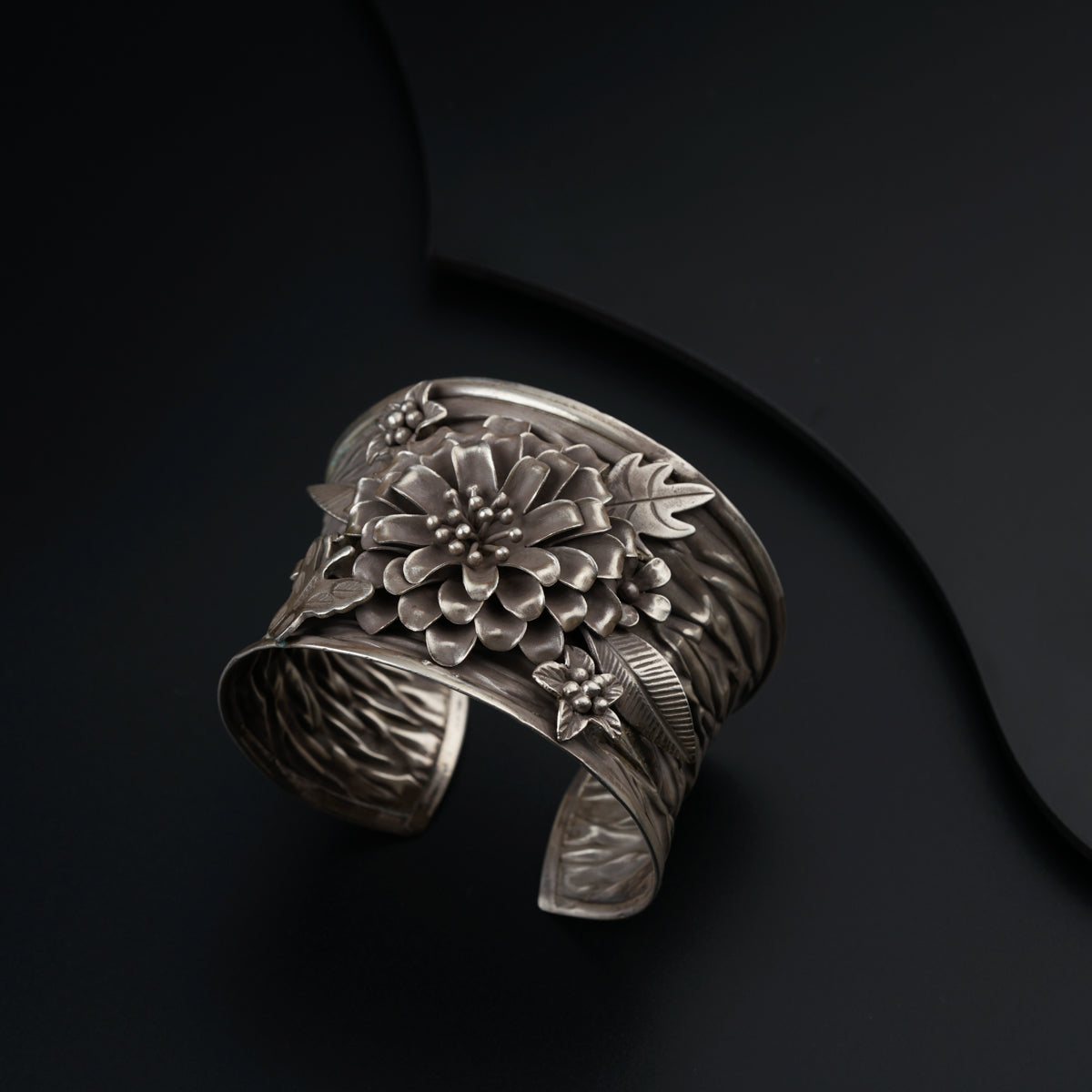 a silver bracelet with a flower design on it
