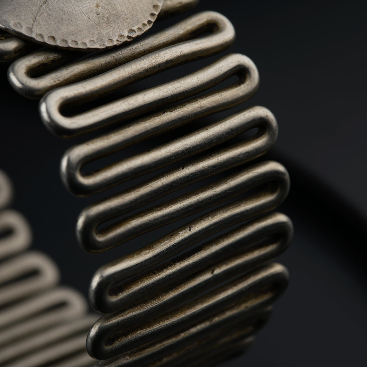 a close up of a metal object on a black surface