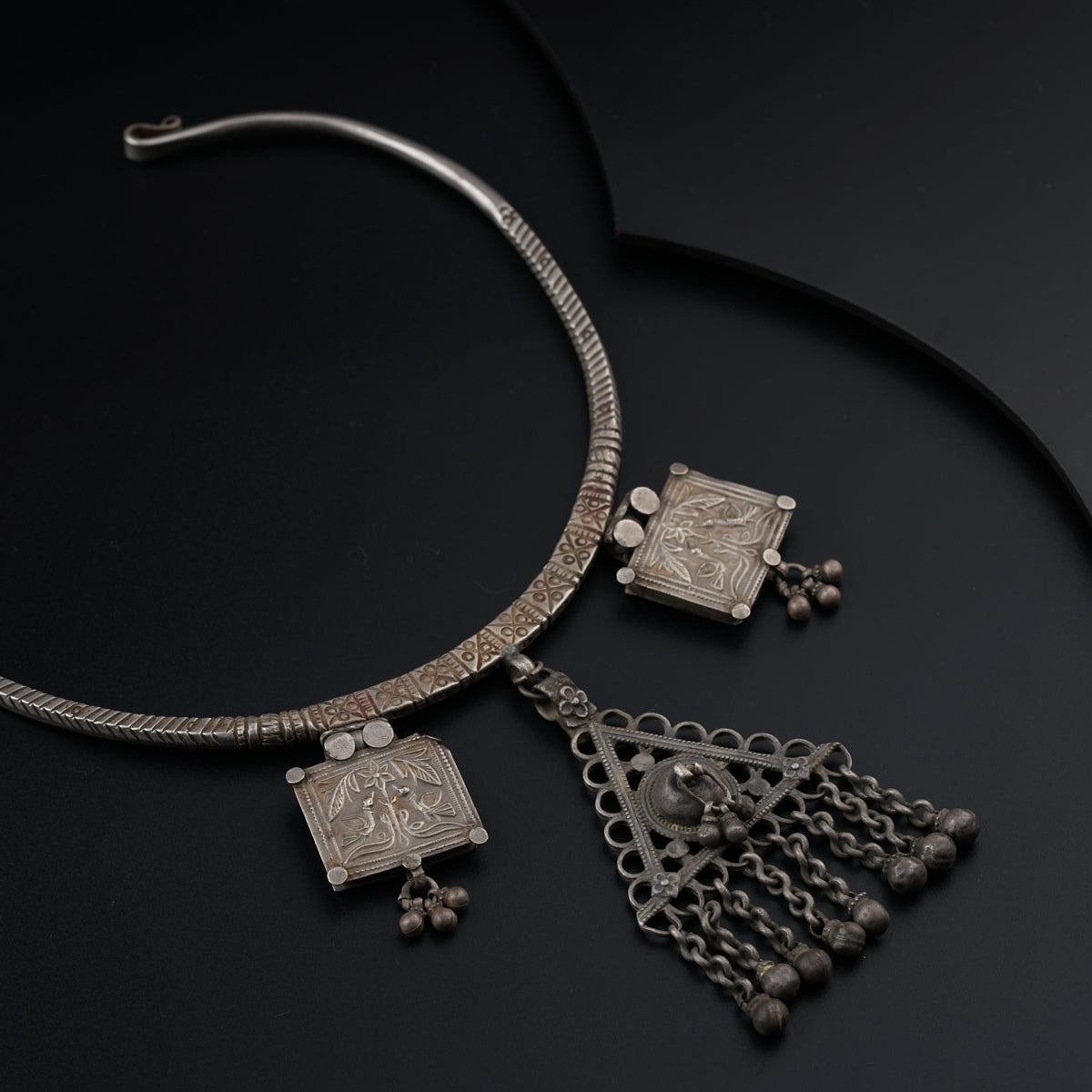 a silver necklace with a design on it
