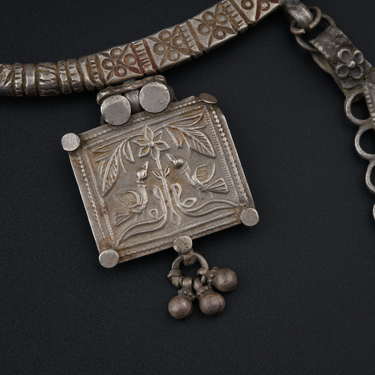 a silver necklace with bells and a pendant