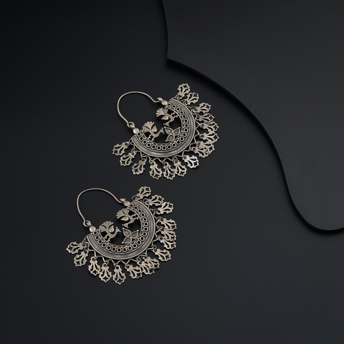 a pair of earrings on a black background