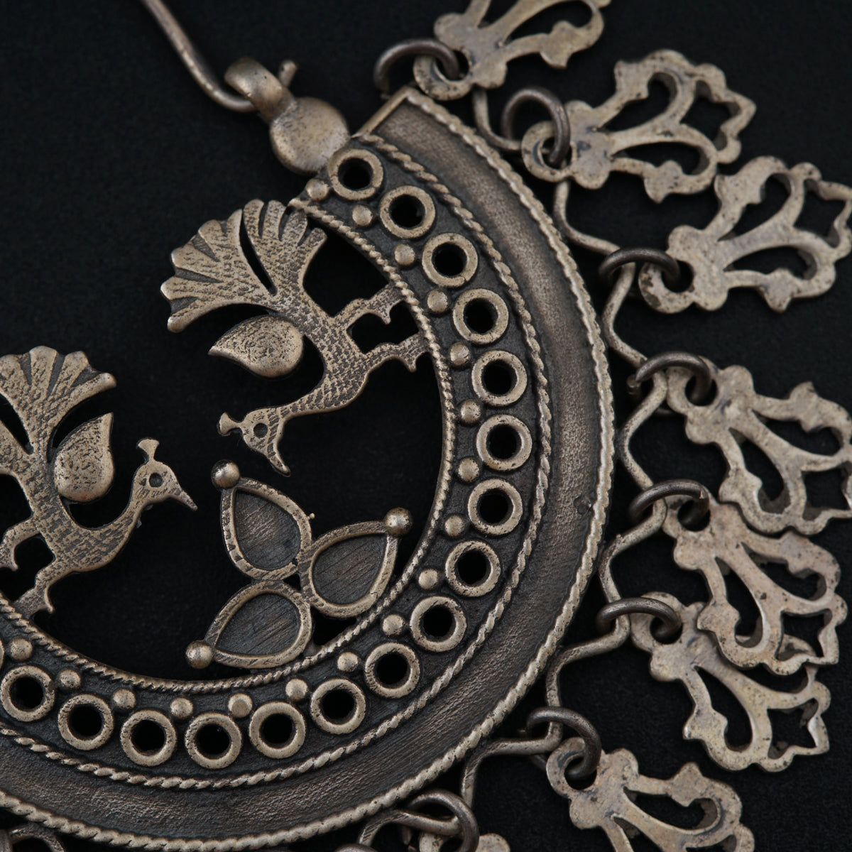 a close up of a necklace with a bird on it