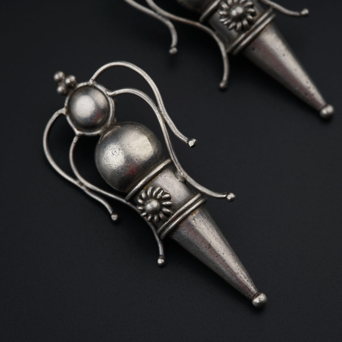 a pair of silver colored objects on a black surface