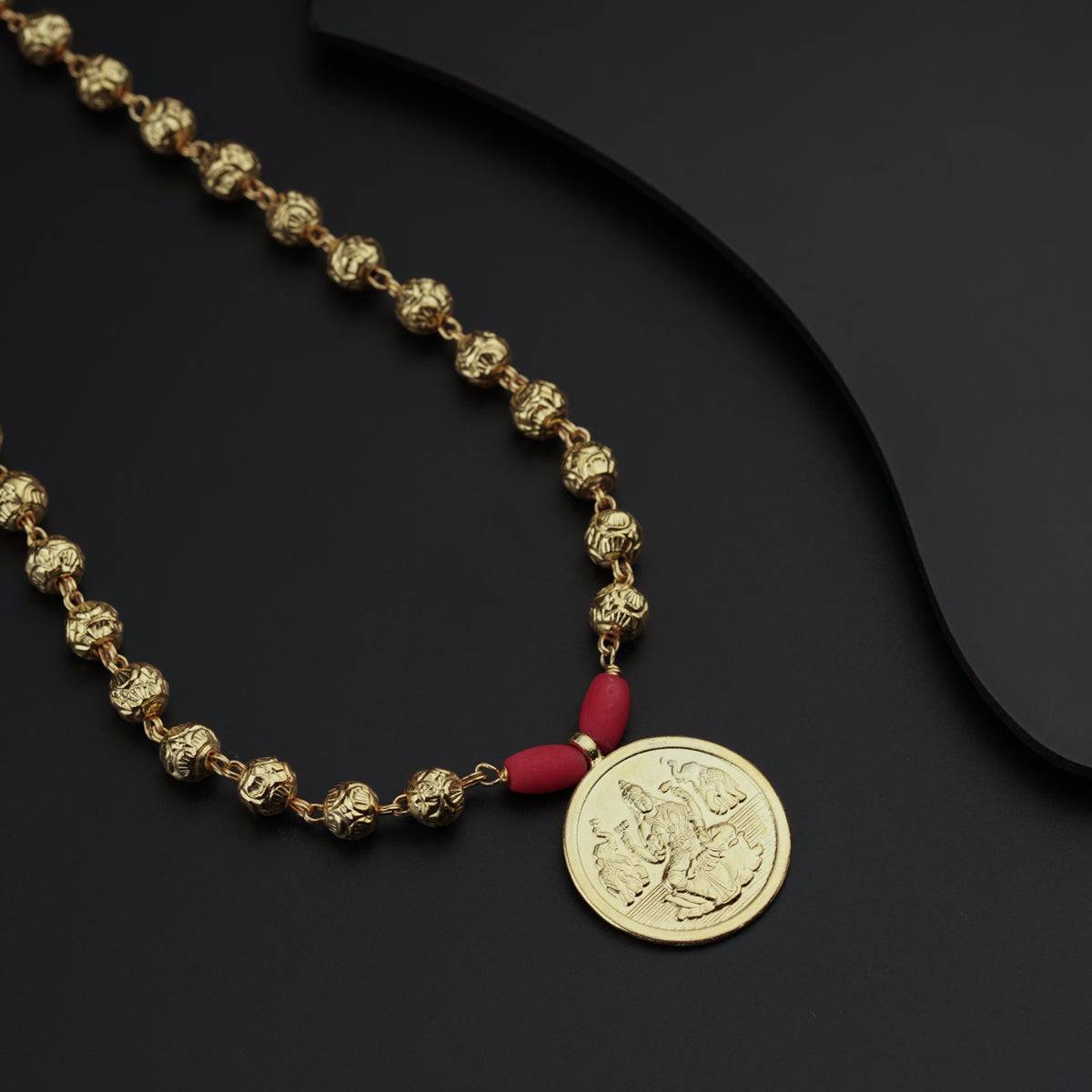 a gold necklace with a coin on it