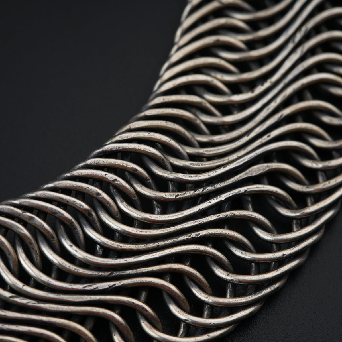 a close up of a metal chain on a black surface