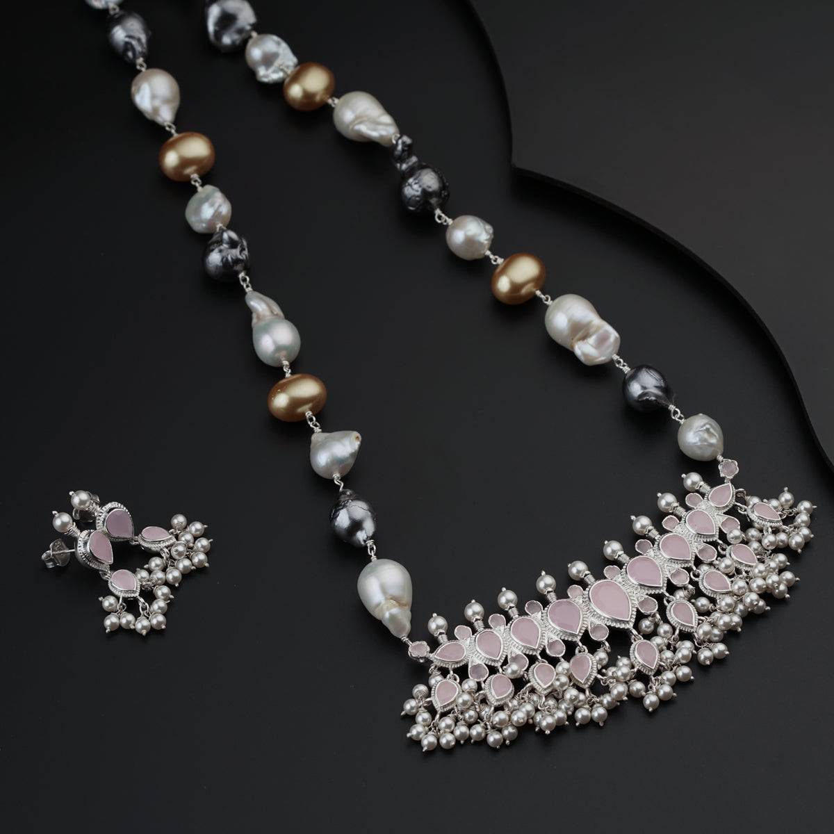 a necklace with pearls and a cross on it