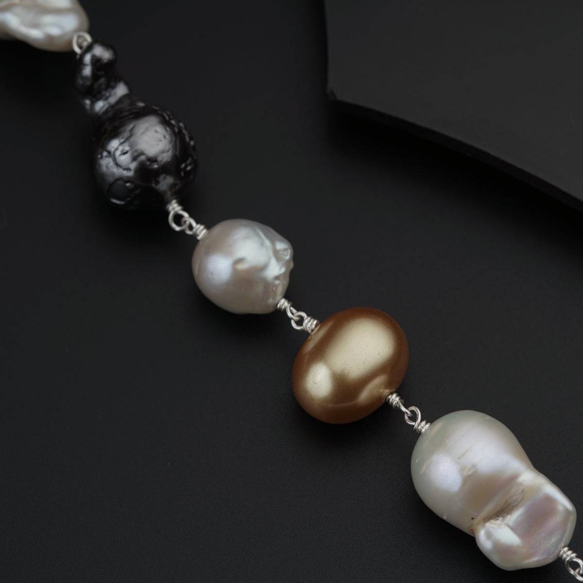 a black and white necklace with pearls on it
