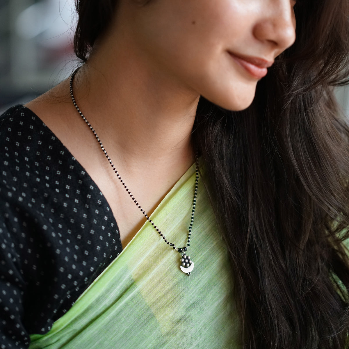 a woman wearing a green sari and a necklace