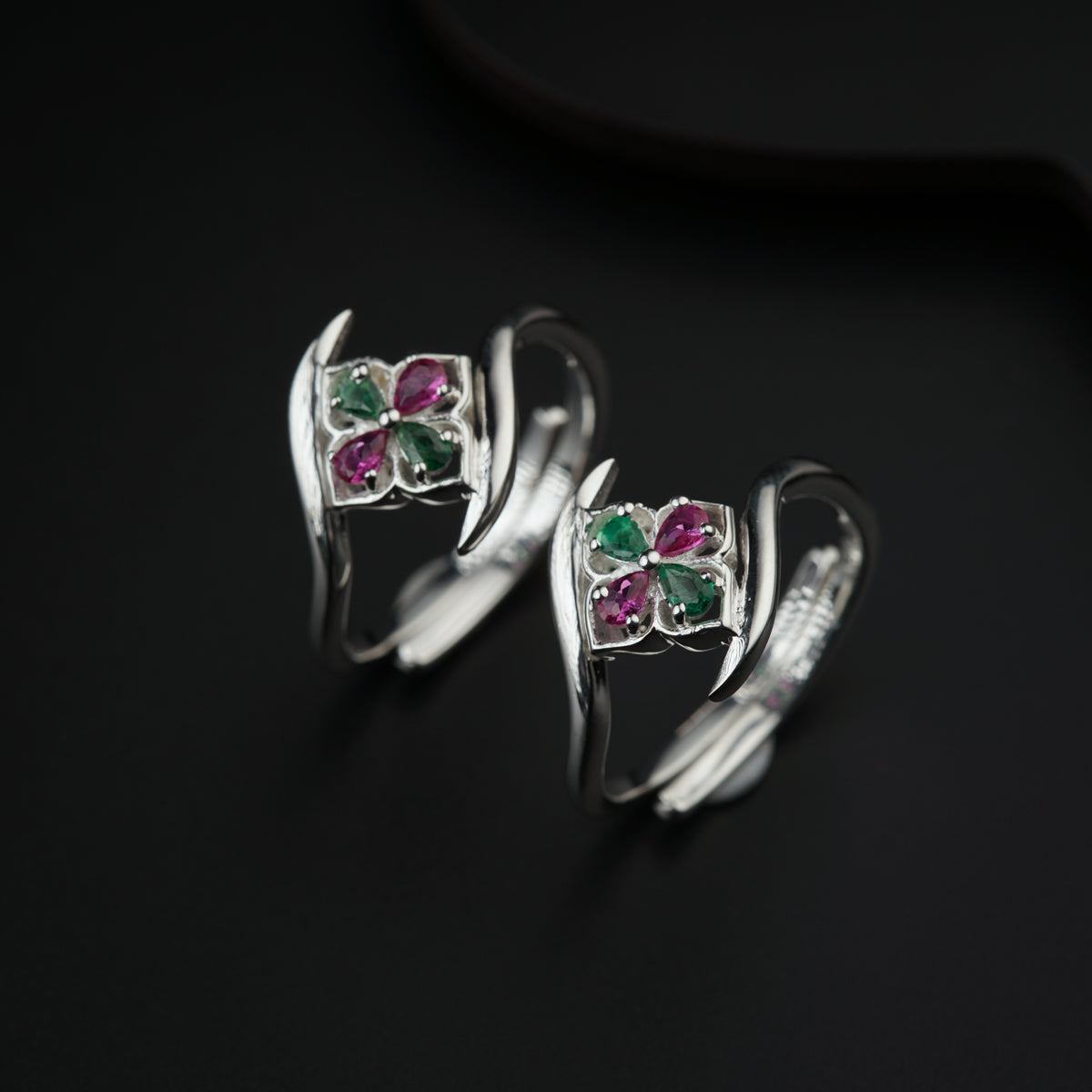 a pair of silver rings with colored stones