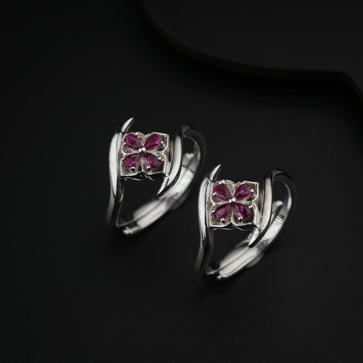 a pair of silver rings with pink stones