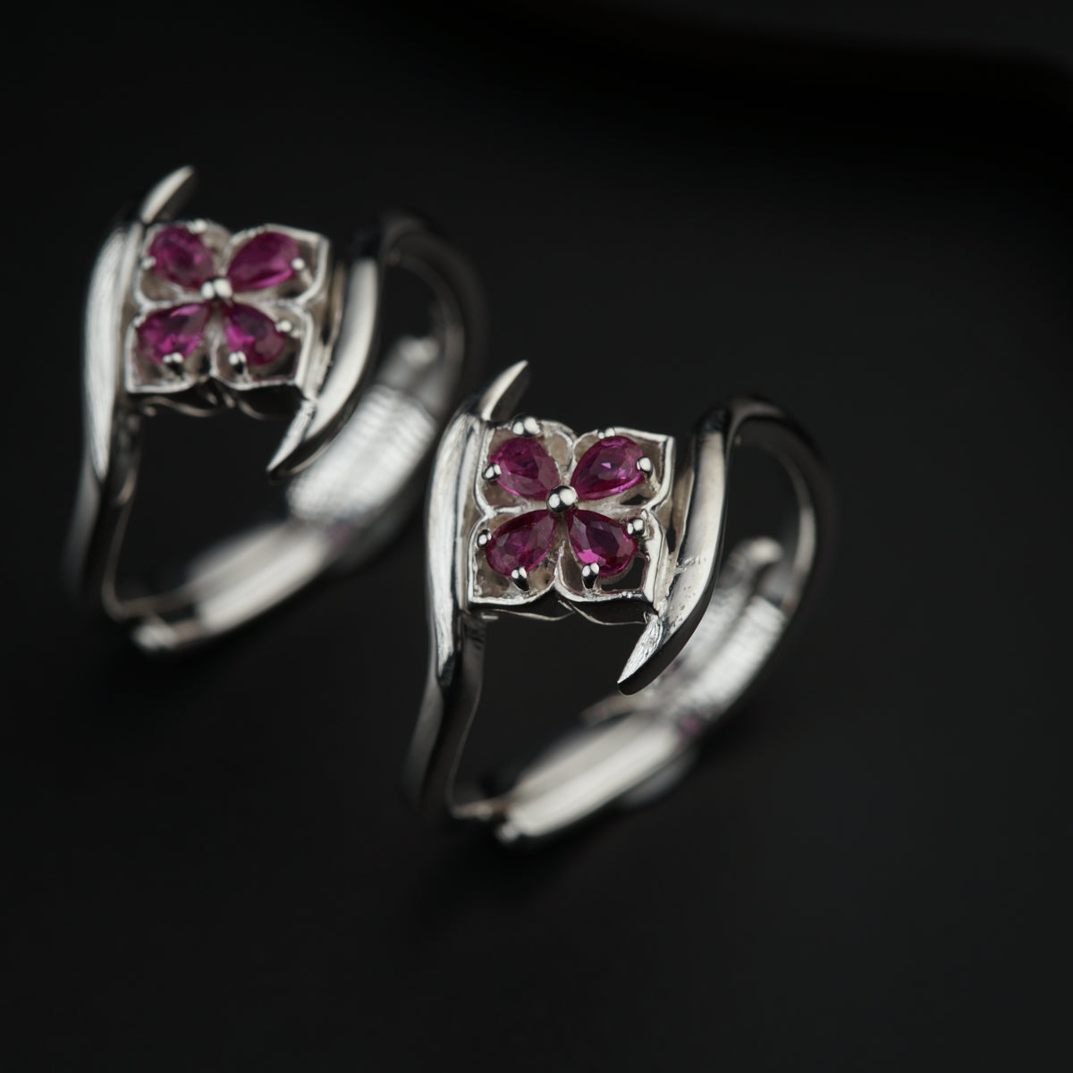 a pair of silver rings with pink stones